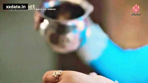 Indian Bhabhi hand with silver ring holding metal cup in blue attire