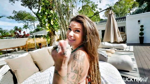 Indica Flower smiling teasingly in bikini, holding toy poolside
