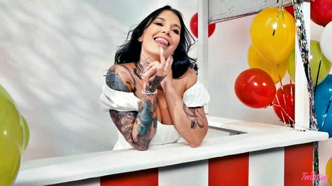 Tattooed Ivy Lebelle smiles playfully in white off-shoulder dress