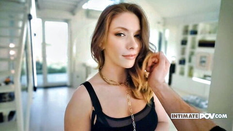 Eveline Dellai close-up in black top, hand caressing her face in intimate POV