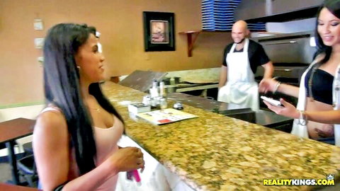 Sexy Asian babes flirting with bald pizza chef at counter in kitchen