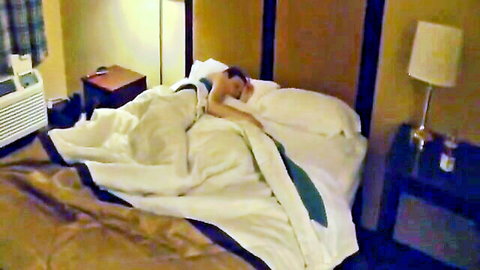 Skinny brunette teen with flat chest lying nude under white sheets on hotel bed