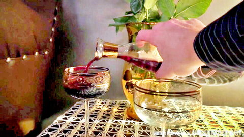 Hand pouring red wine into glasses in elegant cosplay POV setup