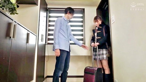 Japanese schoolgirl in uniform greets stepbrother at doorway with suitcase