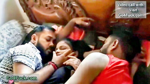 Two Indian men intensely embracing and kissing a South Asian woman in steamy threesome on bed
