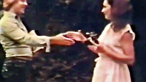 Two smiling vintage women in dresses shaking hands intimately close-up