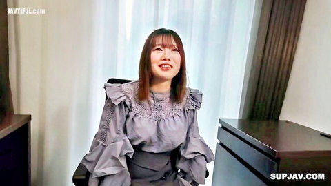 Plump chubby F cup Asian woman in ruffled gray dress smiling seductively