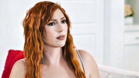 Lauren Phillips redhead tease in tank top, seductive couch pose
