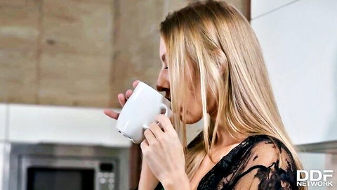 Blonde in sheer black lace lingerie sips coffee in kitchen teasing her small tits