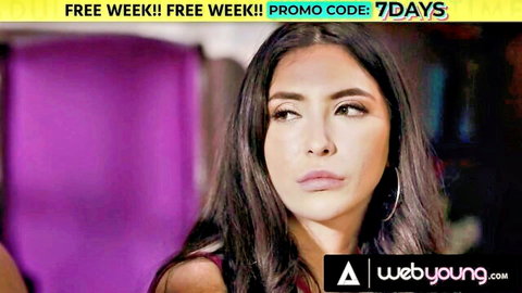 Busty Gabbie Carter in seductive pose, purple backdrop for webyoung lesbian promo