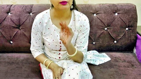 Seductive Indian babe in polka dot salwar kameez flaunting henna hands on couch