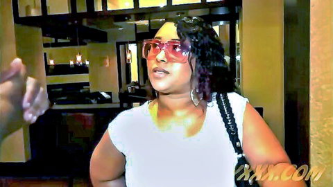Curvy ebony BBW with huge tits in tight white tank top and pink sunglasses smiling in hotel room