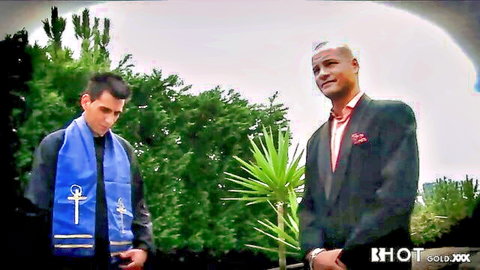 Priest and suited Black man smiling outdoors at wedding
