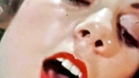 Vintage closeup of ecstatic woman's glossy teary face with open red lips and teeth showing orgasm pleasure