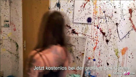 Topless brunette amateur stands naked from behind in paint-splattered room