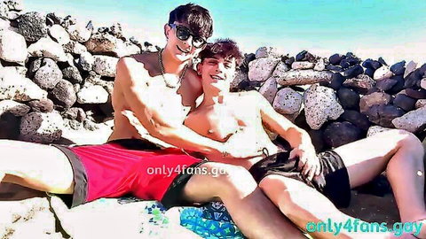 Two shirtless young hunks embracing intimately on sunny beach