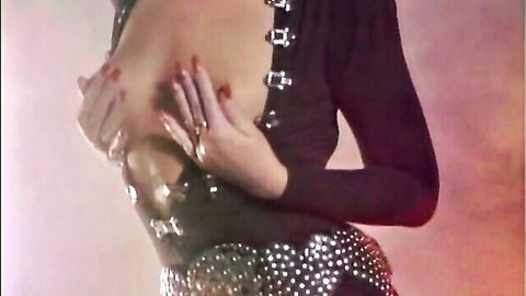 Retro blonde in sexy black buckle dress, hands on cleavage in VCA vintage scene