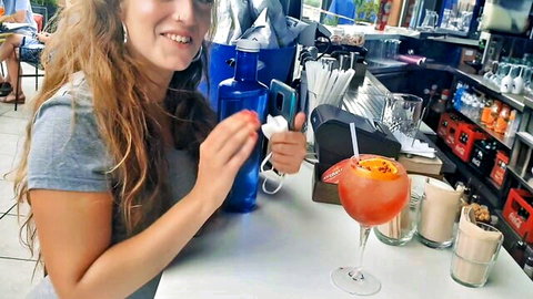 Venom Evil smiling casually at bar with drinks in gray top, wavy hair