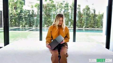 Blonde Royce Swells in orange outfit holding laptop during porn audition