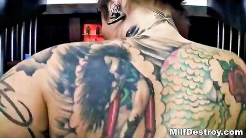 Tattooed MILF with massive tits sucking huge white cock