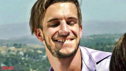 Smiling TS guy in purple shirt with GF outdoors, teasing pegging blowjob scene