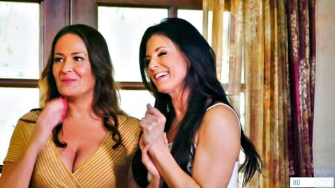 Two busty smiling brunettes showing deep cleavage in low-cut dresses teasing seductively
