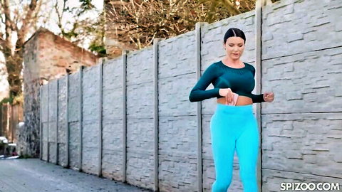 Ania Kinski poses in green crop top and blue leggings outdoors