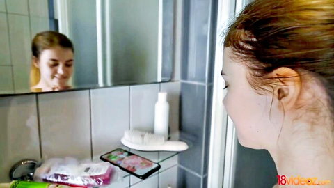 Young teen girl smiling nude in bathroom mirror showing perky small tits