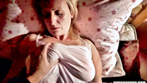 Blonde MILF in sheer white nightie squeezing her visible tits on Xmas pillows