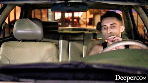 Handsome guy smoking cigarette while driving car at night in Deeper.com video