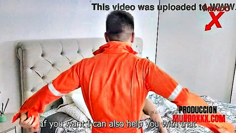 Plumber in orange jumpsuit spreading arms wide on bedroom bed for rough sex