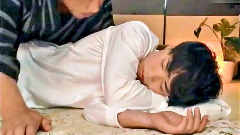 Japanese daddy hovers over sleeping twink boyfriend in white robe, seduction scene