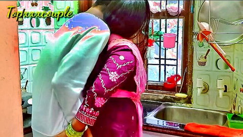 Desi Indian couple hugging intimately in kitchen, husband embraces saree-clad wife from behind