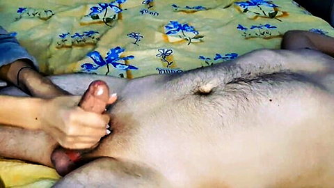 Woman's hand firmly strokes hairy South Asian man's big erect cock in closeup handjob