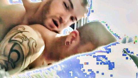 Tattooed man passionately kissing his Japanese friend bareback style
