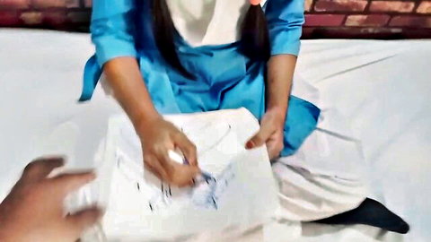 Sexy South Asian woman in blue salwar kameez drawing on paper with man's hand on bed