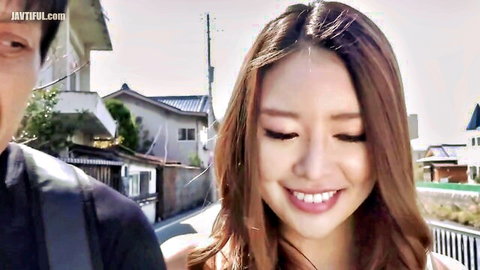 Cute Asian babe with perky tits smiles happily at guy walking on sunny Japanese street