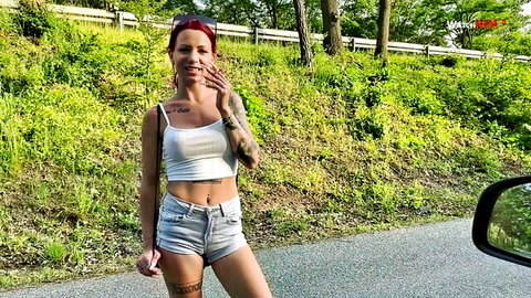 Redhead JaneDavi in tight white tank and denim shorts outdoors, tattoos visible