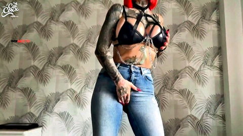 Tattooed redhead Cat-Coxx in black harness lingerie and jeans teasing