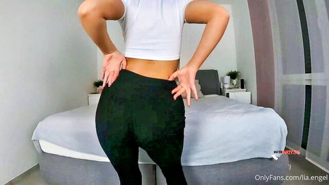 LiaEngel teasing in white crop top and tight black leggings from behind