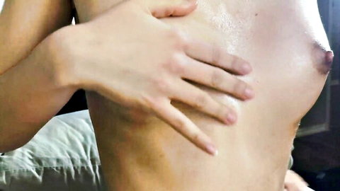 Hand squeezing shiny oiled petite tit with erect nipple closeup