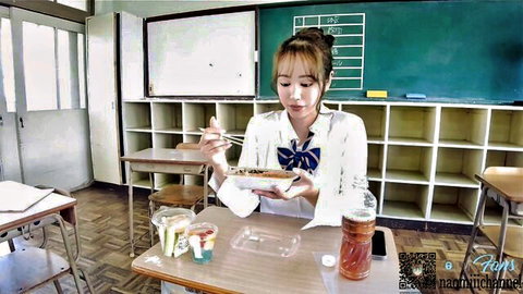 Cute Asian teen schoolgirl in white blouse and bowtie eating noodles in classroom