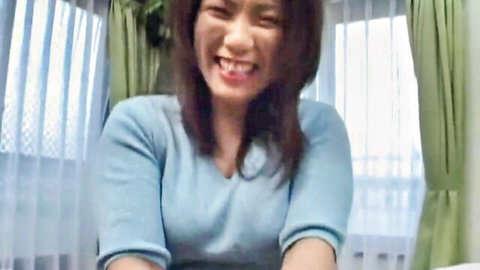 Smiling mature Japanese woman in blue V-neck sweater, fulfilling 3P fantasies