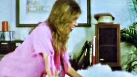 Blonde vixen in pink top leaning forward in classic porn tease