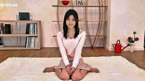 Tsukasa A kneels in pink top and skirt, teasing with smile