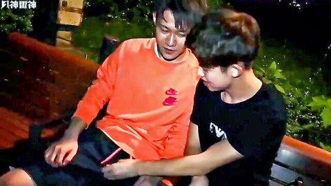 Two hot Asian guys in intimate outdoor embrace from real threesome video