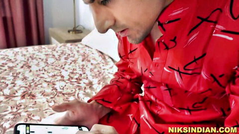 Indian step-bro in red shirt focused on phone, home alone setup