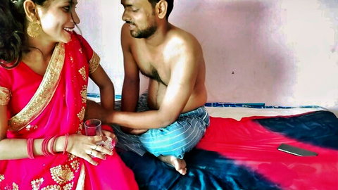 Indian bhabhi in red saree with shirtless jija ji smiling intimately on bed