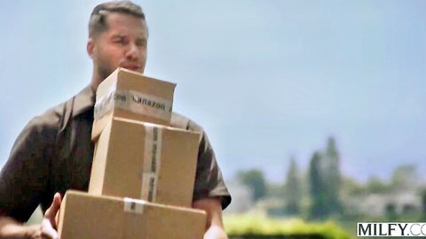 Delivery man carrying stacked Amazon boxes in American MILF behind-the-scenes scene