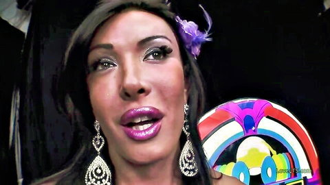 Glamorous shemale with purple lips, feather headpiece in dominant adult pose